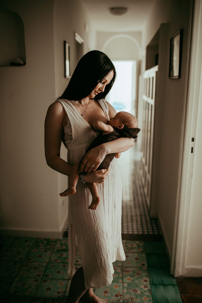 Washington State Family Photographer, woman standing and breastfeeding in hallway